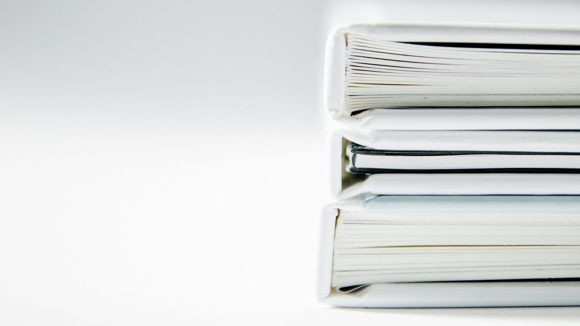 Stack of thick white binders viewed close up