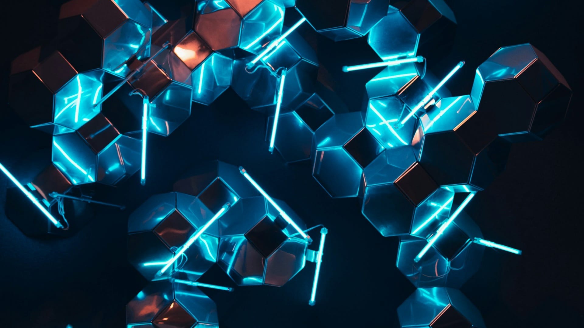 Metallic hexagonal modules lit by neon tubes on a dark background