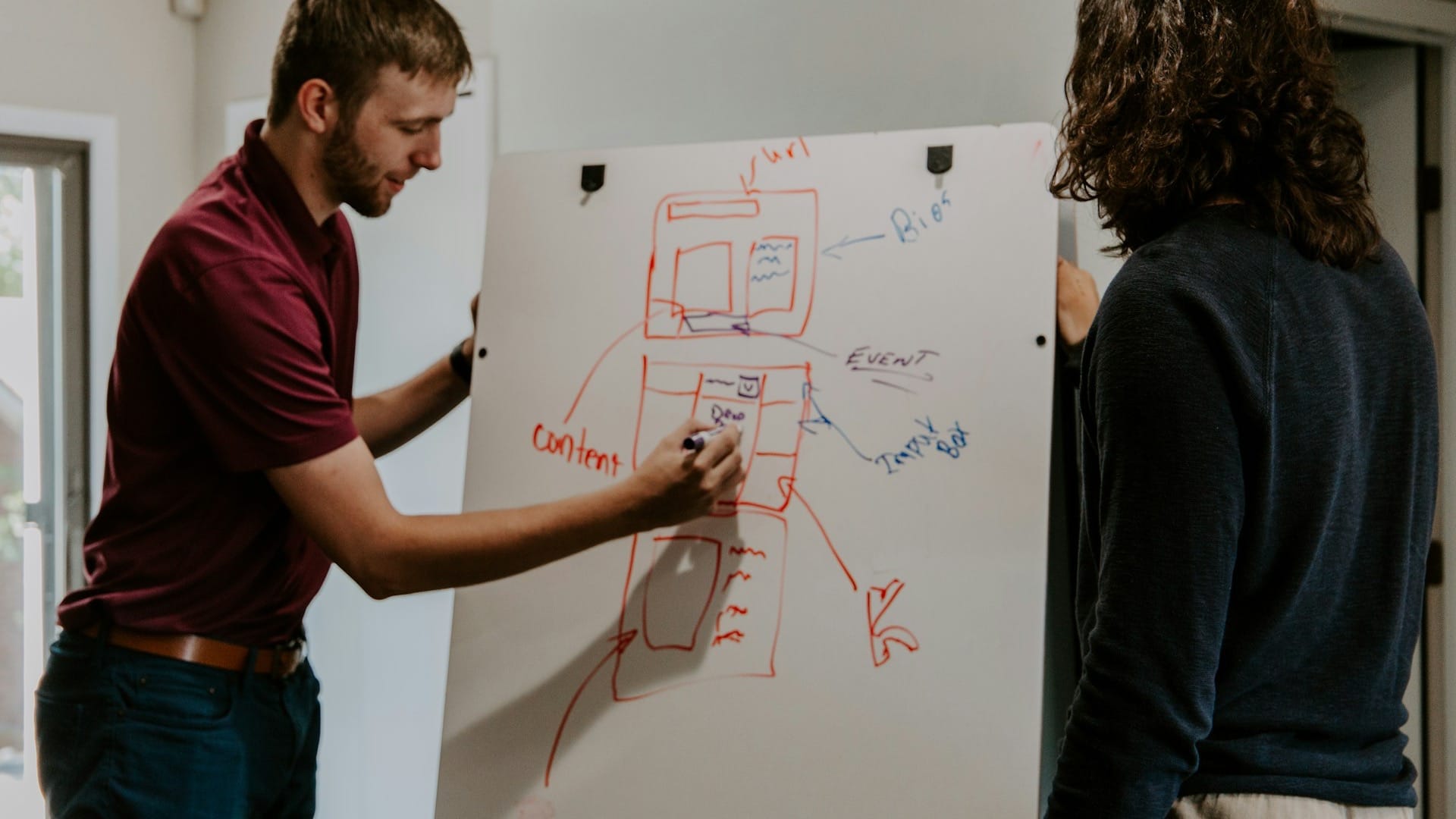 A person sketching a strategy diagram on a whiteboard