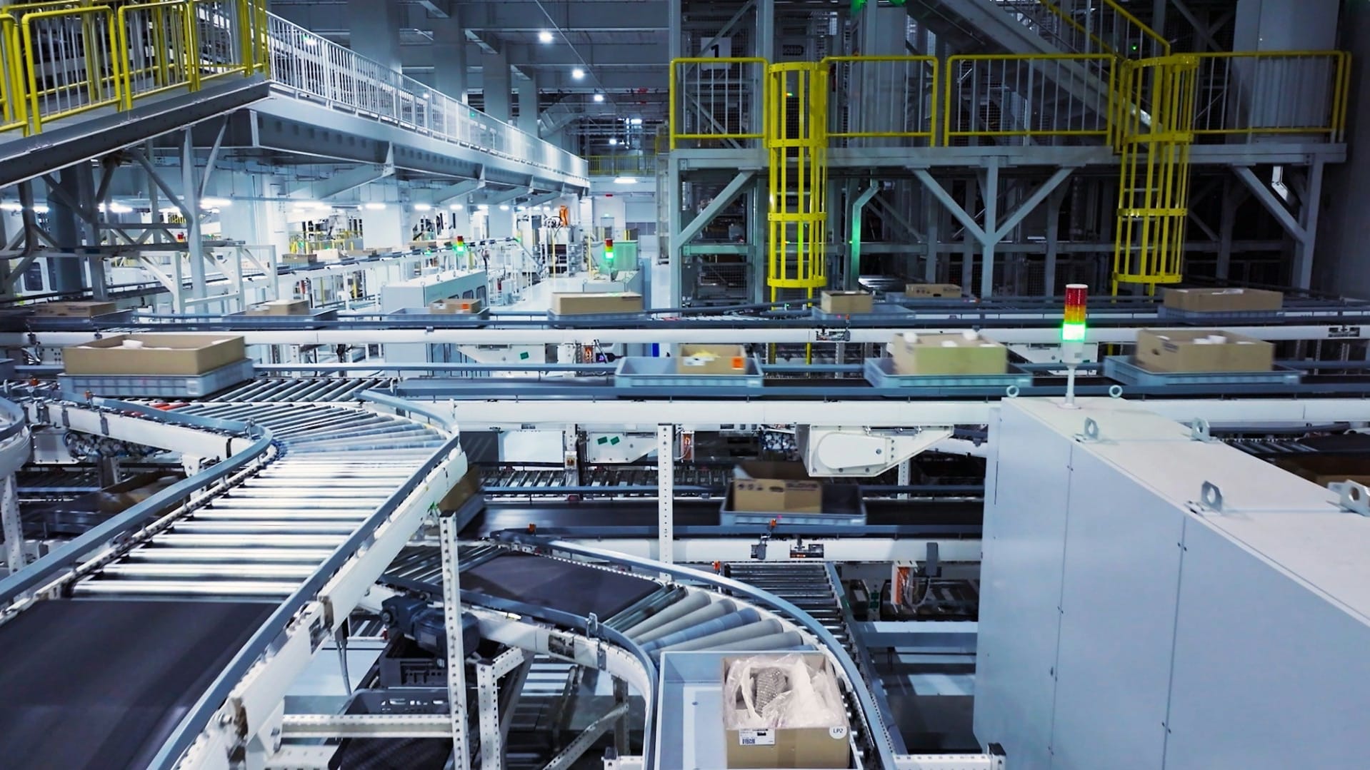 Cardboard boxes moving along a conveyor belt inside an industrial sorting facility