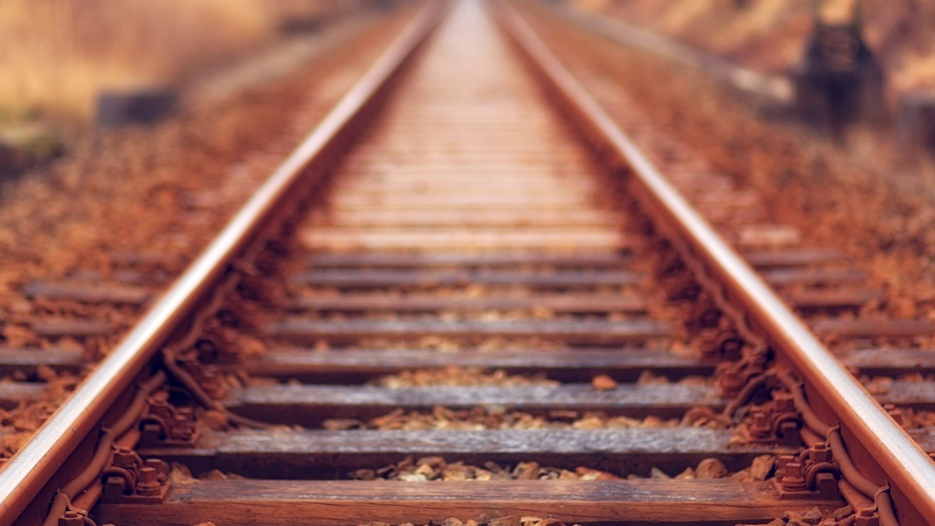 A single railway track receding into the distance, the rails blurred by shallow focus