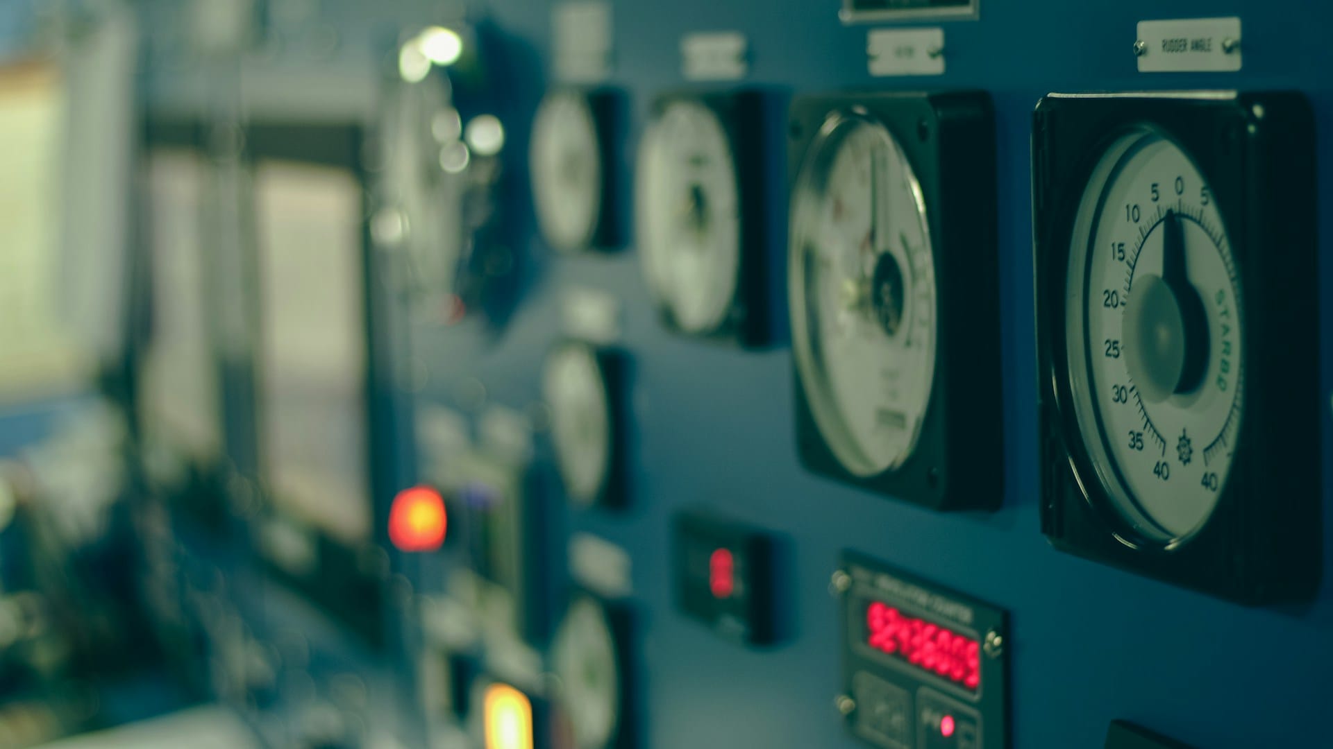 A close-up of an industrial control panel covered in grey switches and indicator buttons
