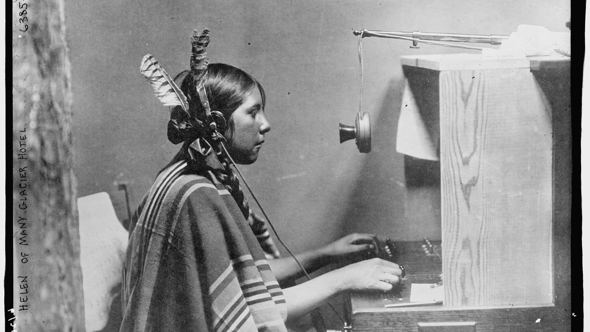 A telephone switchboard operator connecting calls by hand at a plugboard in 1925.