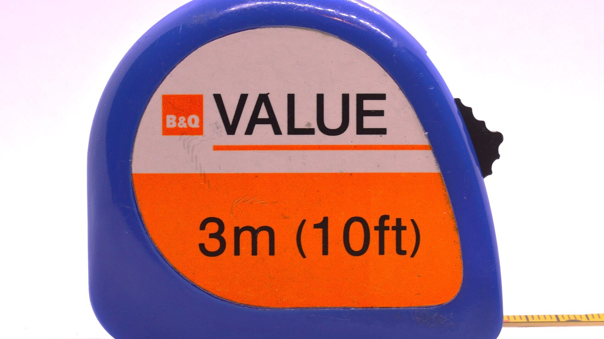 A retractable steel tape measure extended across a plain background.