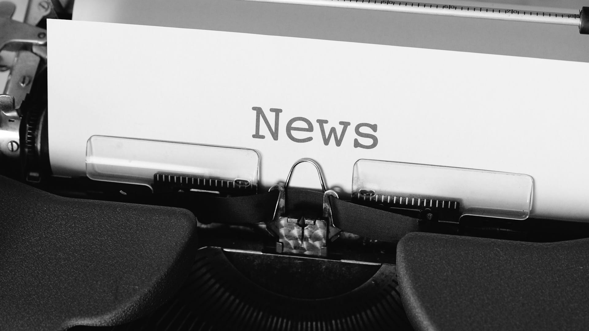 A black-and-white photograph of a typewriter with the word News on its paper.