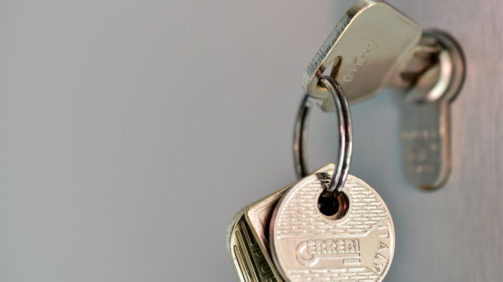 Metal keys hanging from a ring in a door lock.